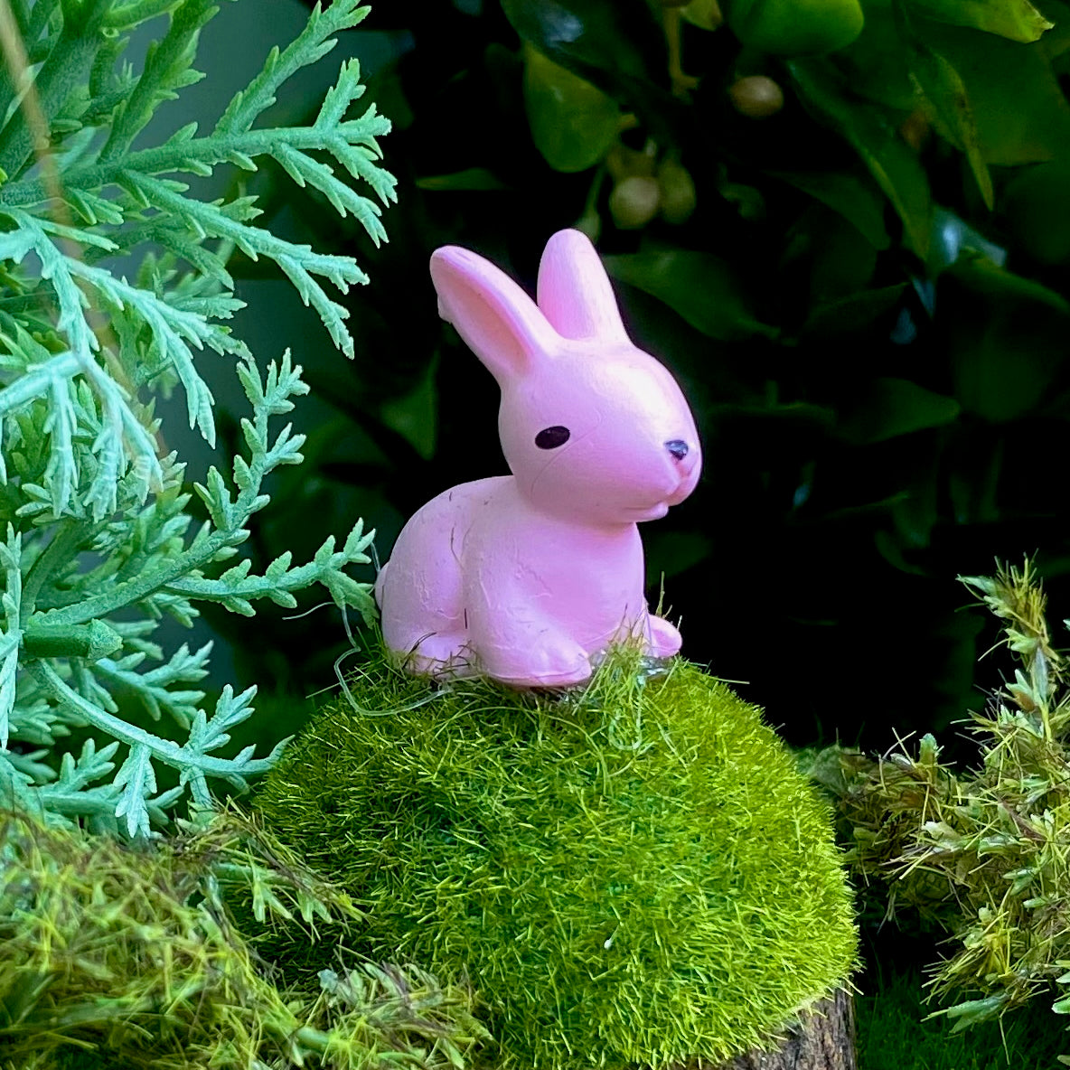 Pink sitting bunny rabbit mounted on a moss mound for a fairy garden decoration