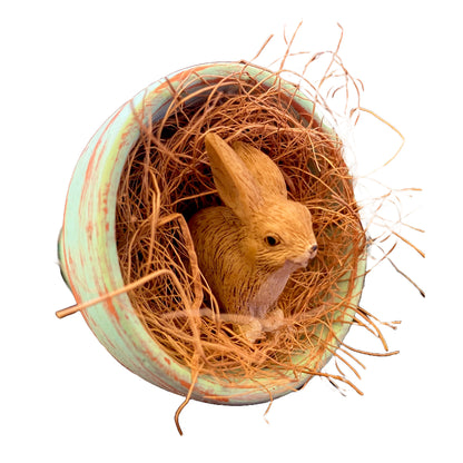 Cute fairy garden bunny rabbit in a flower pot nestled in straw